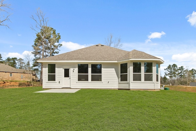 back of house with a patio, a yard, and roof with shingles