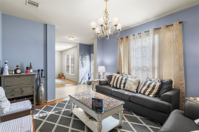 living area featuring a notable chandelier and visible vents