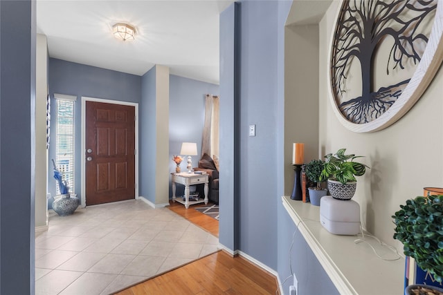 entryway with baseboards and light wood finished floors