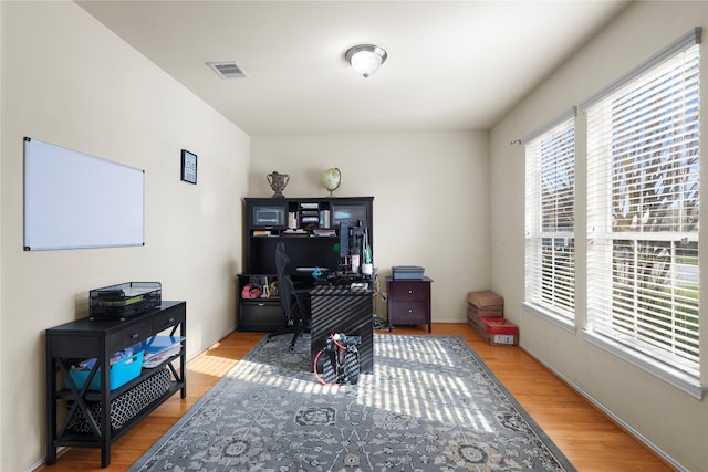 home office with visible vents, baseboards, and light wood-style floors