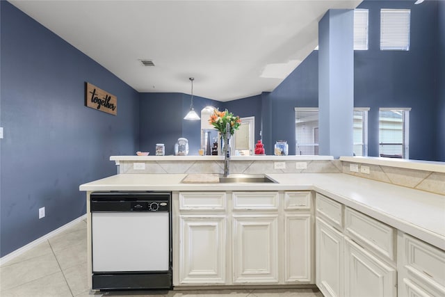 kitchen with light countertops, light tile patterned floors, white dishwasher, white cabinets, and a sink