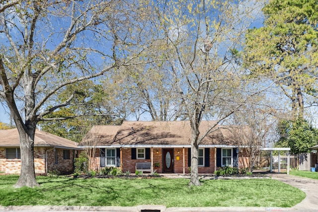 single story home with brick siding, driveway, and a front yard