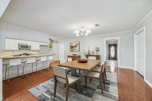 dining area featuring visible vents, a chandelier, ornamental molding, and tile patterned flooring