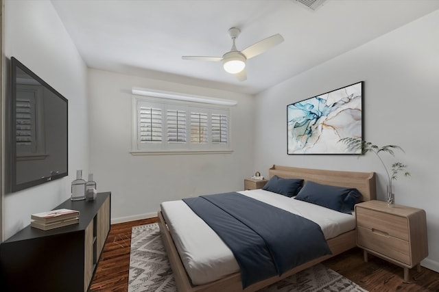 bedroom with baseboards, dark wood-style floors, and a ceiling fan