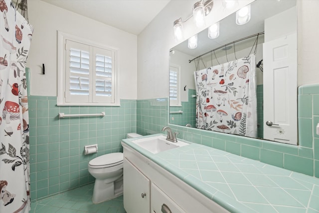 full bathroom with curtained shower, toilet, vanity, wainscoting, and tile walls