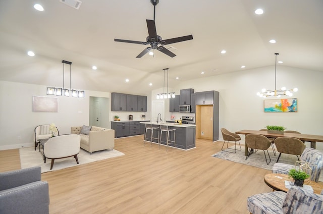 living area featuring vaulted ceiling, light wood-style flooring, recessed lighting, and visible vents