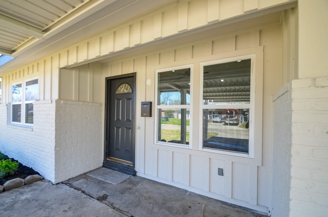 property entrance with brick siding and board and batten siding