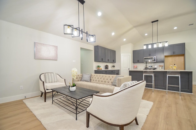 living room featuring recessed lighting, light wood-style flooring, baseboards, and vaulted ceiling