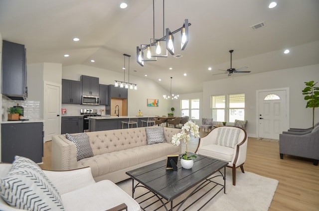 living room with recessed lighting, visible vents, ceiling fan with notable chandelier, and light wood-style floors