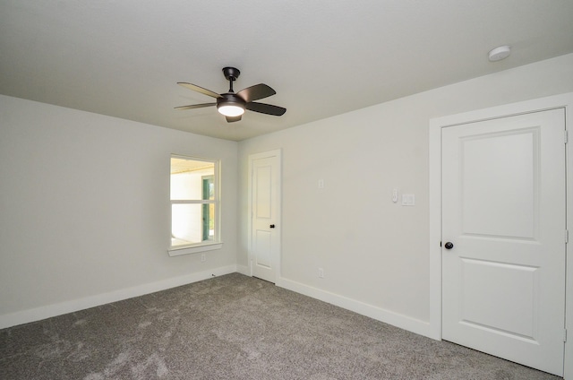 carpeted empty room with baseboards and ceiling fan