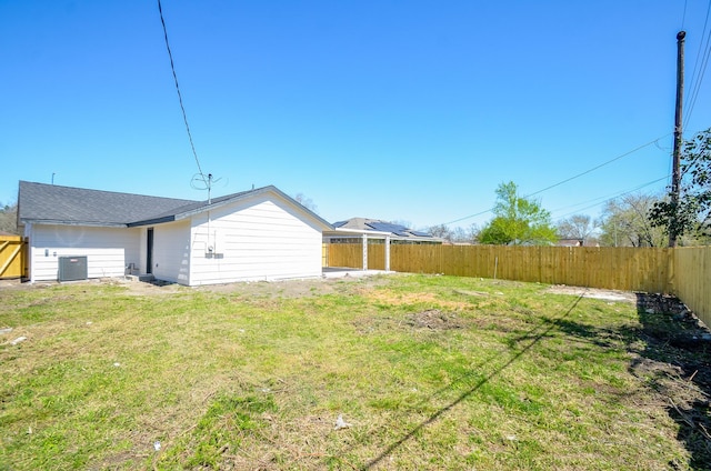 view of yard featuring central AC and fence