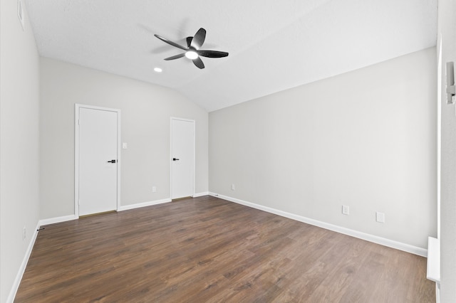 unfurnished bedroom with a ceiling fan, dark wood-type flooring, baseboards, and vaulted ceiling