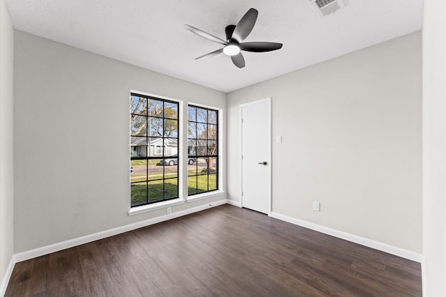 unfurnished room with dark wood-type flooring, plenty of natural light, baseboards, and ceiling fan