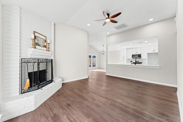 unfurnished living room featuring visible vents, a fireplace, dark wood-style flooring, ceiling fan, and vaulted ceiling