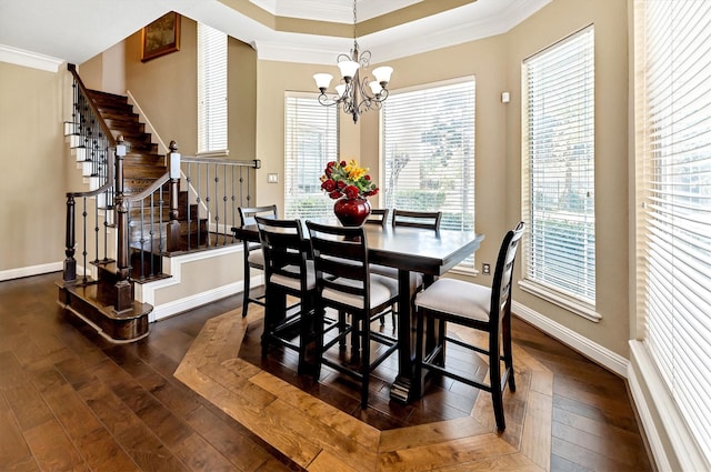 dining space with dark wood-type flooring, baseboards, crown molding, and an inviting chandelier