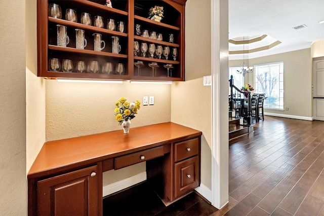 interior space featuring visible vents, baseboards, ornamental molding, an inviting chandelier, and dark wood-style flooring