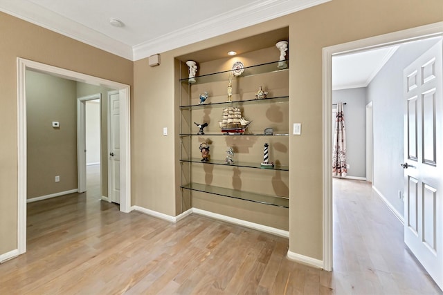 hall with wood finished floors, baseboards, and ornamental molding