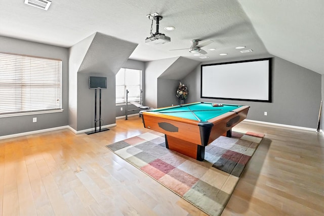 recreation room featuring vaulted ceiling, wood finished floors, visible vents, and ceiling fan