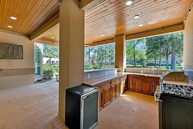 view of patio with a sink, wine cooler, and exterior kitchen