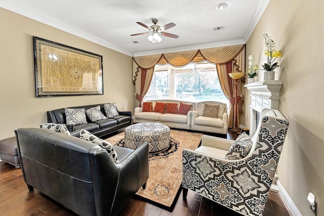 living area with visible vents, wood finished floors, ceiling fan, and ornamental molding