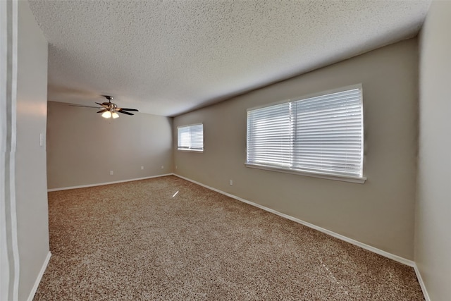 spare room with a ceiling fan, baseboards, a textured ceiling, and carpet flooring