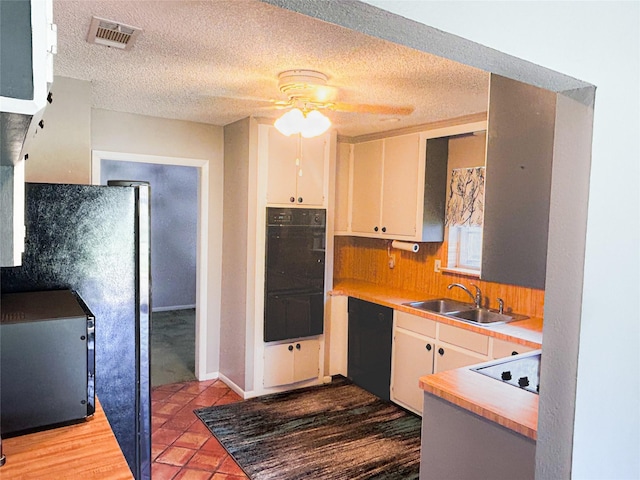 kitchen featuring visible vents, ceiling fan, light countertops, black appliances, and a sink