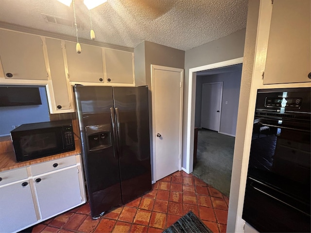 kitchen featuring white cabinetry, a textured ceiling, black appliances, and a warming drawer