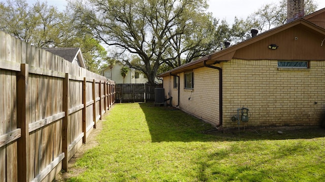 view of yard with central air condition unit and a fenced backyard