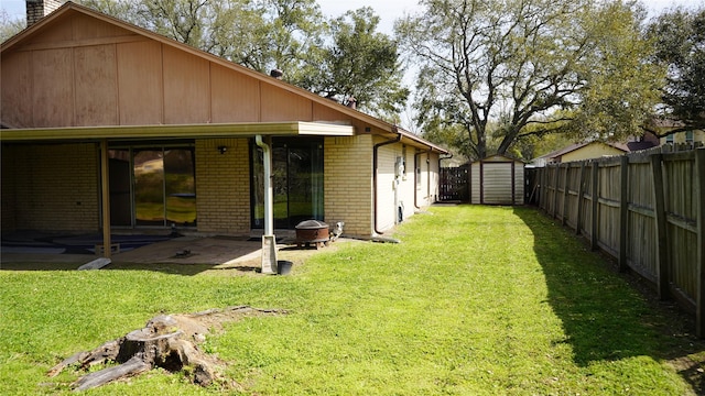 view of yard with a fenced backyard, a patio area, a storage shed, and an outdoor structure