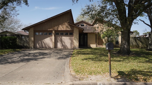 mid-century modern home featuring brick siding, concrete driveway, an attached garage, and fence