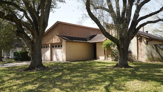 view of front facade with a front yard, an attached garage, brick siding, and driveway