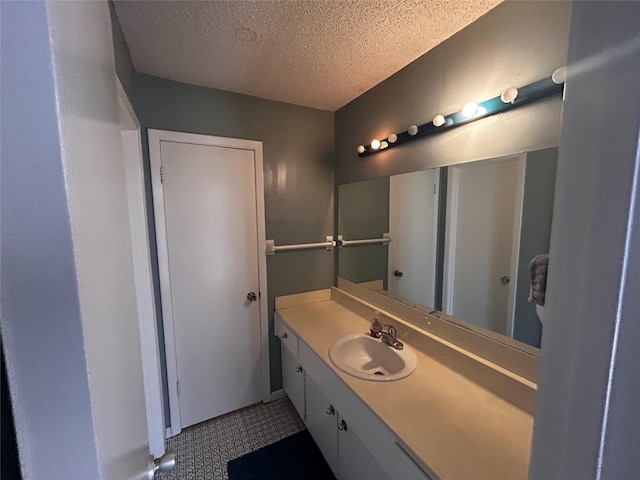 bathroom featuring a textured ceiling and vanity