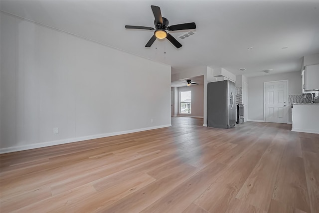 unfurnished living room with baseboards, a ceiling fan, visible vents, and light wood-type flooring