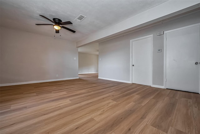 spare room with visible vents, baseboards, wood finished floors, and a ceiling fan