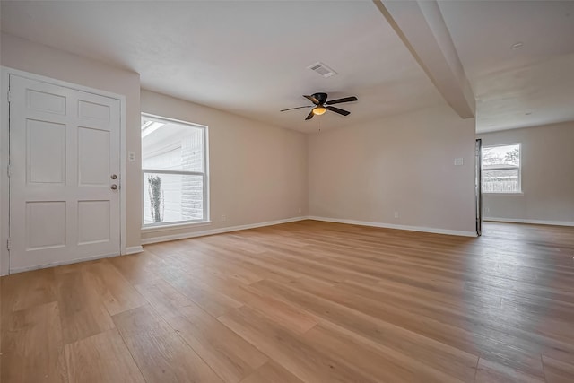 spare room with visible vents, baseboards, light wood-type flooring, beam ceiling, and a ceiling fan