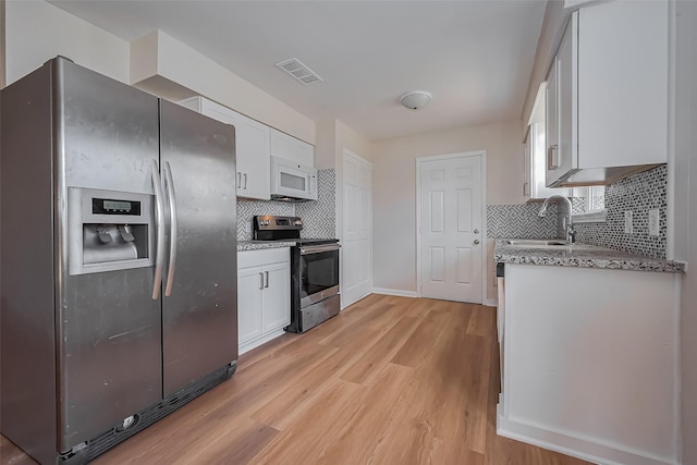 kitchen featuring white cabinetry, light wood-style floors, visible vents, and appliances with stainless steel finishes