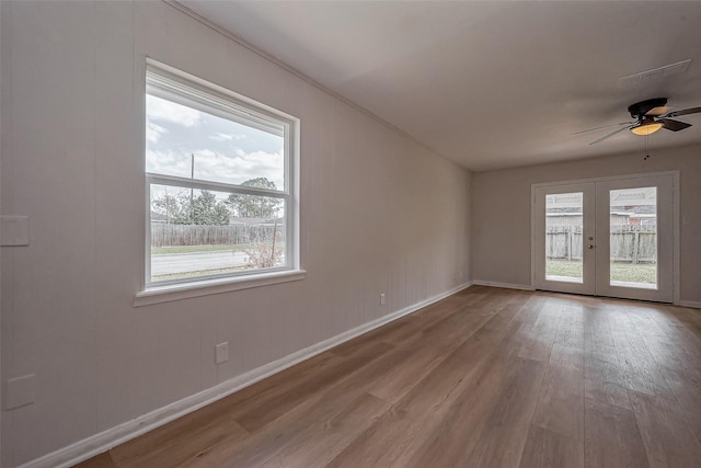 unfurnished room with wood finished floors, baseboards, french doors, and ceiling fan