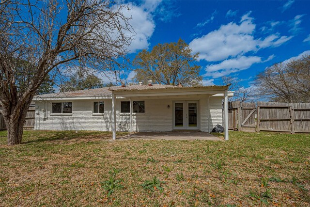 back of property with a patio, a yard, french doors, and fence