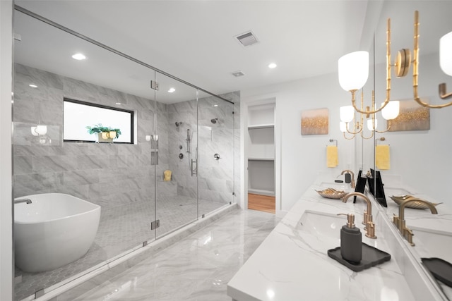 full bath with visible vents, a sink, a shower stall, double vanity, and a soaking tub