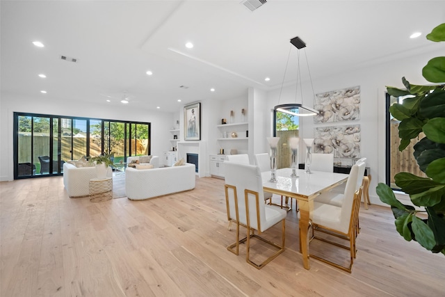 dining area featuring recessed lighting, visible vents, a fireplace, and light wood finished floors