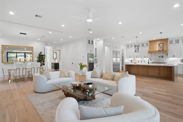 living area featuring a ceiling fan, recessed lighting, visible vents, and light wood finished floors