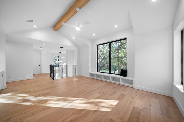 empty room featuring visible vents, light wood-style flooring, lofted ceiling with beams, and baseboards