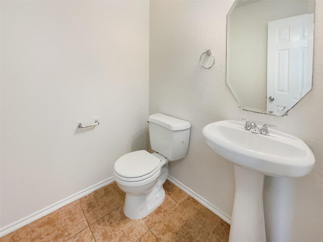 bathroom featuring tile patterned flooring, toilet, and baseboards