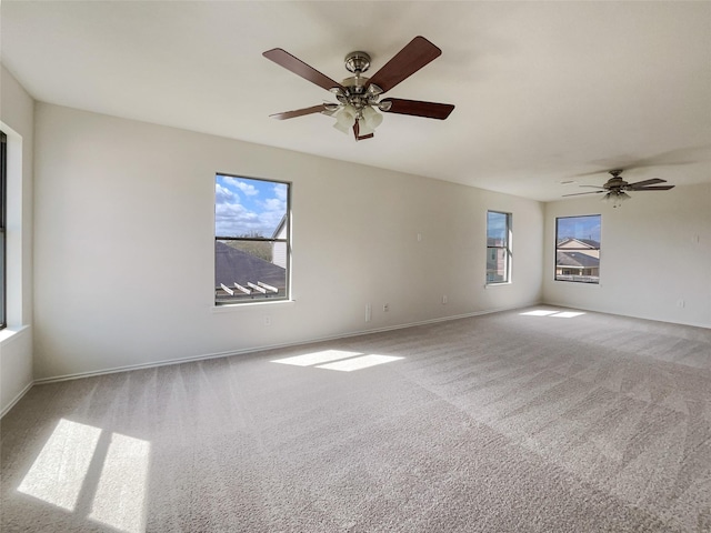 spare room with a ceiling fan, carpet, and baseboards