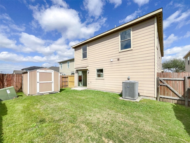 rear view of house with an outbuilding, a lawn, a fenced backyard, and a shed