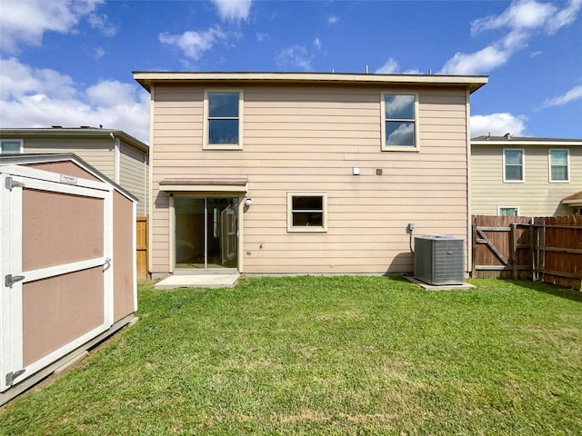 back of property featuring cooling unit, a yard, a storage shed, and fence