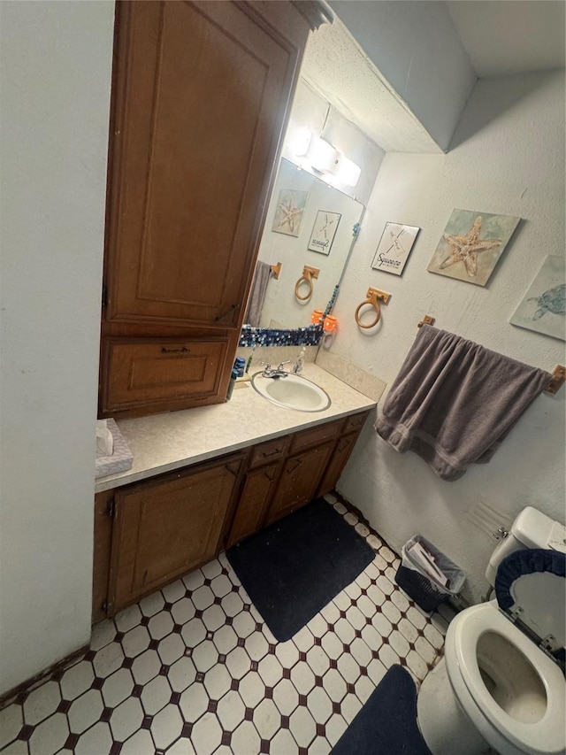 bathroom featuring vanity, tile patterned floors, and toilet