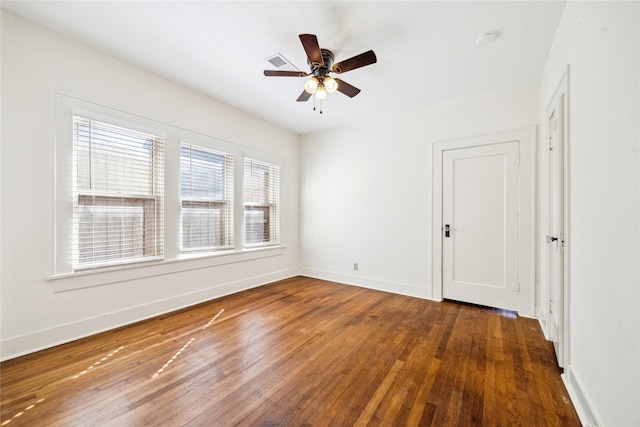 spare room with visible vents, a ceiling fan, baseboards, and hardwood / wood-style floors