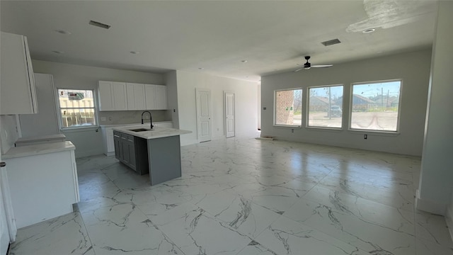 kitchen with visible vents, marble finish floor, and a sink