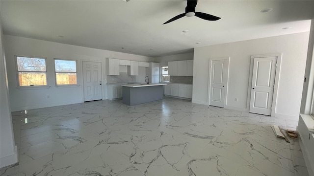 interior space featuring marble finish floor, ceiling fan, and a sink